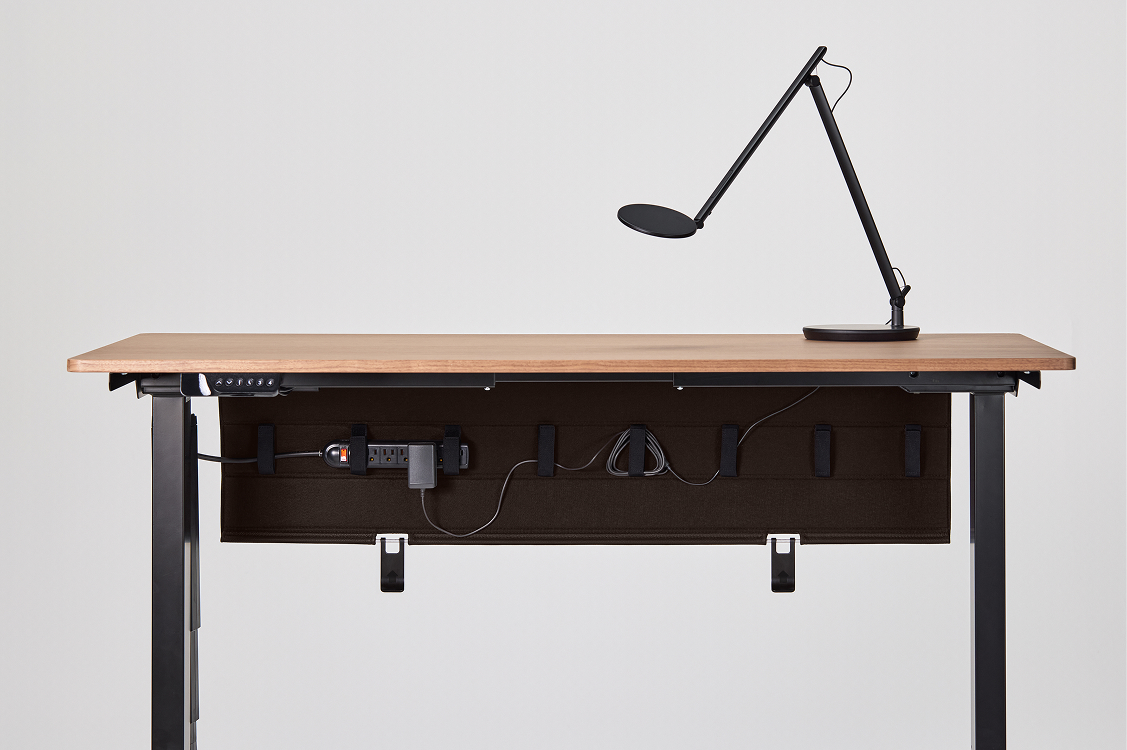 Netjes weggewerkte kabels onder een bureau